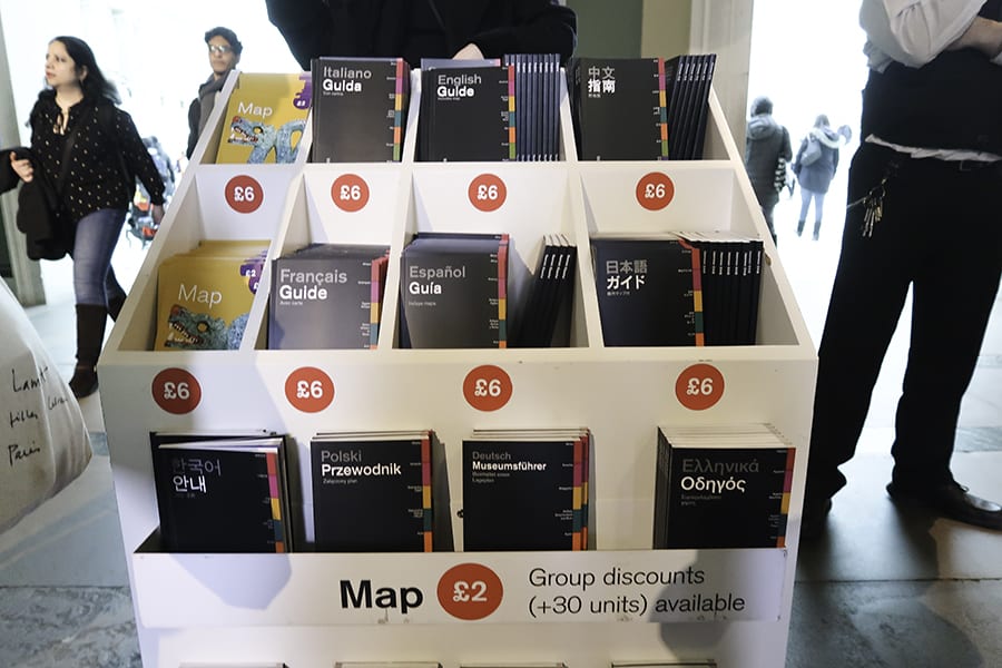 The British Museum, London - 30 Top Tips For Your Visit 7 White stand with black guide books in different languages Italian, English, Mandarin, French, Spanish, Japanese, Arabic, Dutch, Greek and Polish and yellow maps