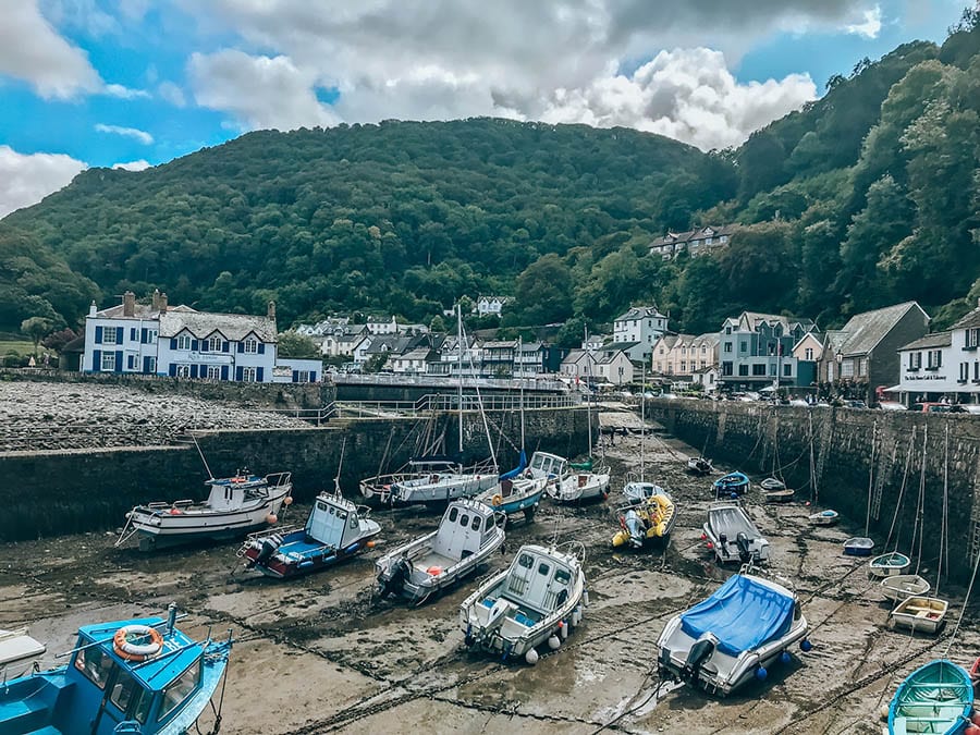 10+ of the Best Weekends in Devon 12 Lynton and Lynmouth harbour. The tide is out and the boats are resting on the ground. Thee are houses and mountains around