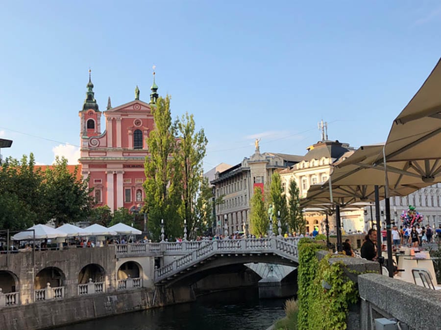 Ljubljana with the river running through the middle and a bridge over it, with buildings in the background