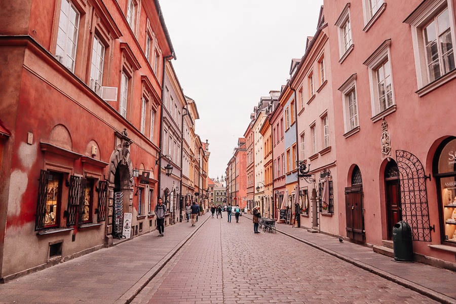 a long street with burnt sienna coloured houses and cobbles on the streets