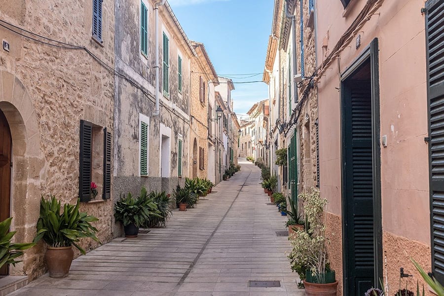 narrow paved street with old stone houses either side