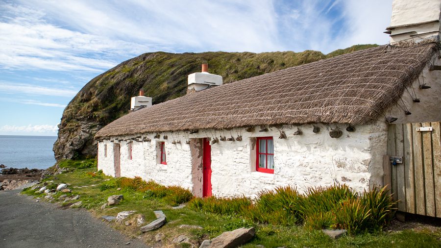 15+ Of The Best Things To Do On The Isle Of Man 17 white Manx house with red door and window frames