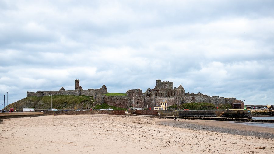 15+ Of The Best Things To Do On The Isle Of Man 9 Peel Castle in the distance with sandy beach in front