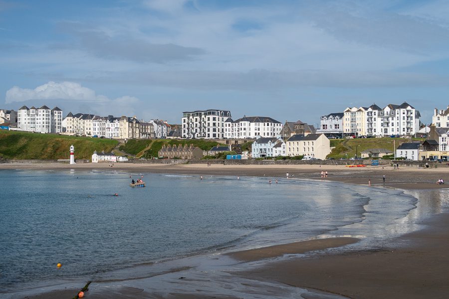 15+ Of The Best Things To Do On The Isle Of Man 10 beach with the sea coming in and tall white guest houses behind