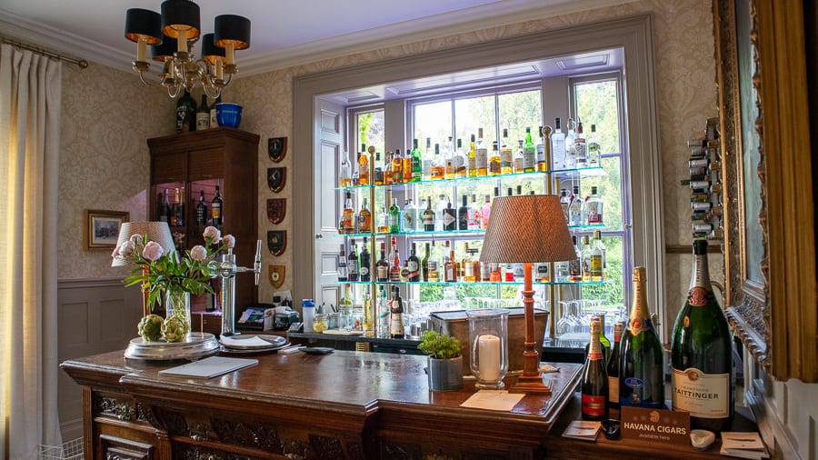 The Burleigh Court Hotel & Restaurant, Luxury in the Cotswolds 18 bar with bottles of alcohol on glass shelves on the window