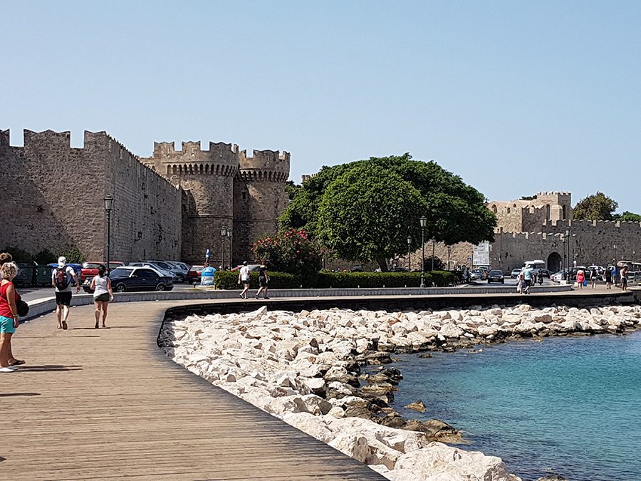 25 Amazing Destinations for Winter Sun around the World 23 Palace of The Grand Master in Rhodes, Greece with a wide boardwalk in front, above white rocks and sea