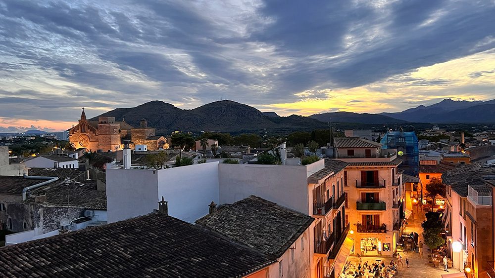 27 of the best things to do in Alcudia, Mallorca 5 View of Alcudia Old Town from the roof top with sunset lighting the sky