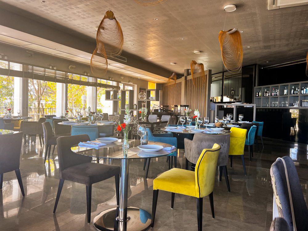 Sawa Taste Of Tunisia: Explore The Amazing Food Of Tunisia 53 Inside the RestÔ with yellow, grey and blue chairs and glass tables
