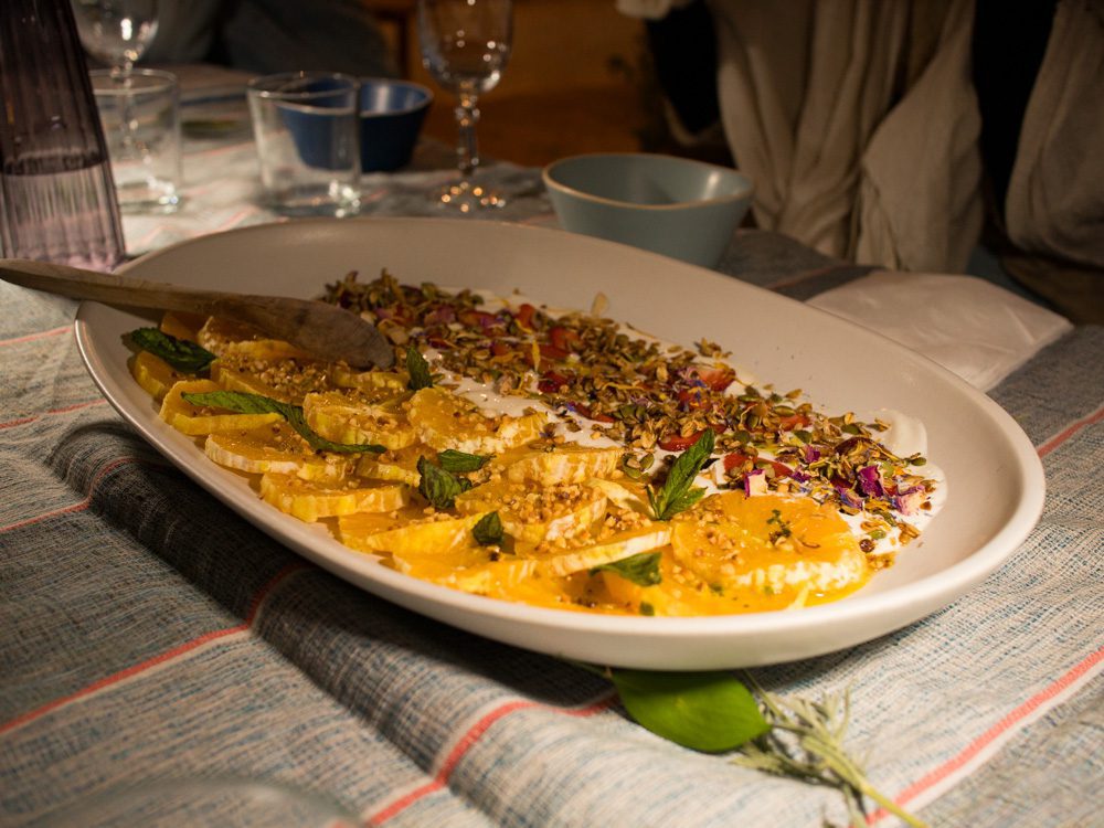 Sawa Taste Of Tunisia: Explore The Amazing Food Of Tunisia 60 dessert with yoghurt, orange slices rose and pistachios on a white platter