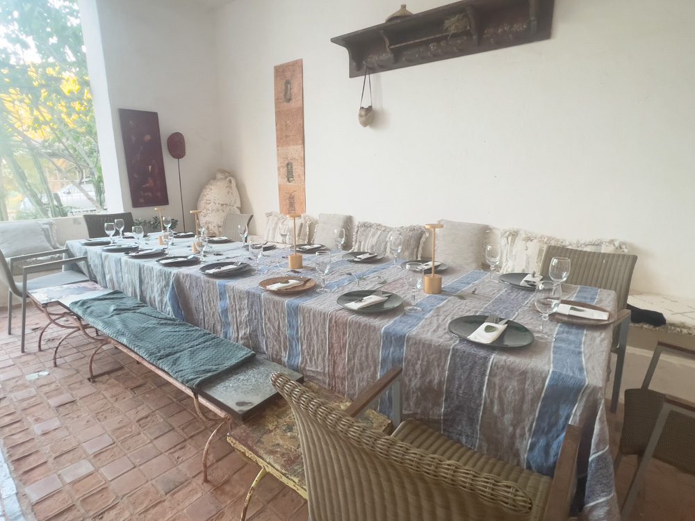Sawa Taste Of Tunisia: Explore The Amazing Food Of Tunisia 57 long table with grey and blue striped tablecloth set with plates and glasses