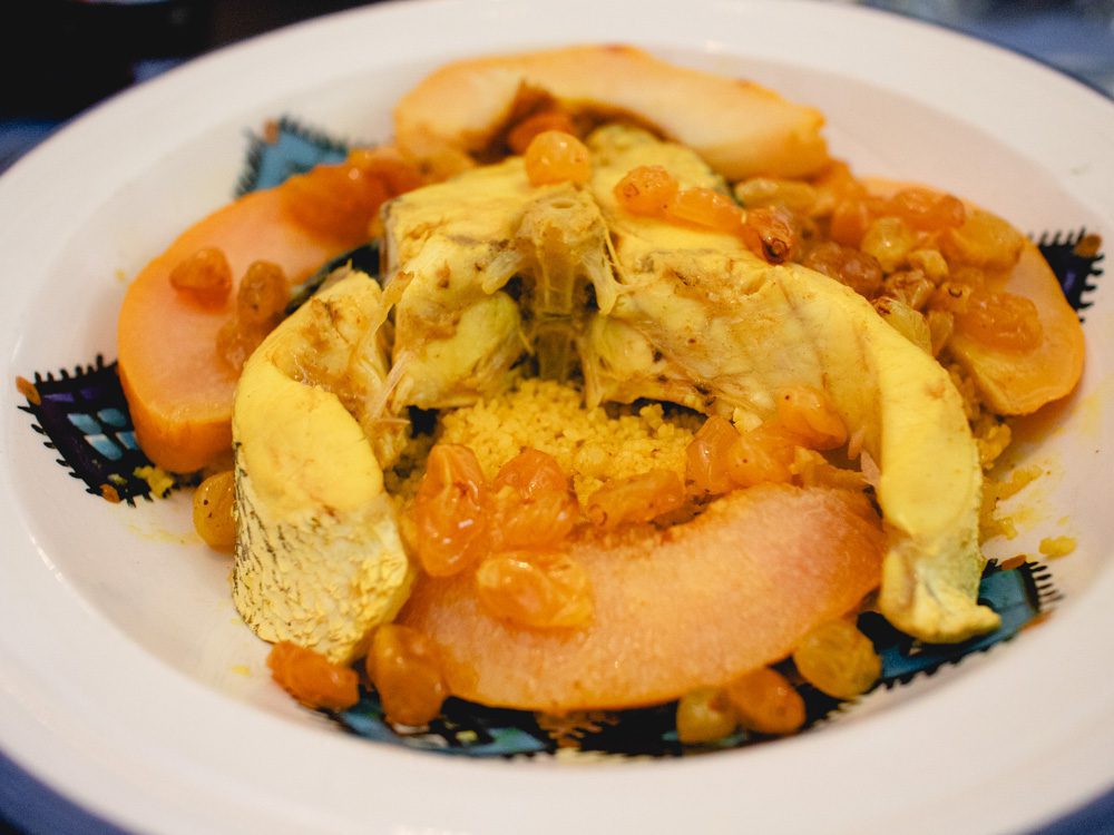 Sawa Taste Of Tunisia: Explore The Amazing Food Of Tunisia 27 Fish with couscous, peaches and sultanas on a white and blue plate