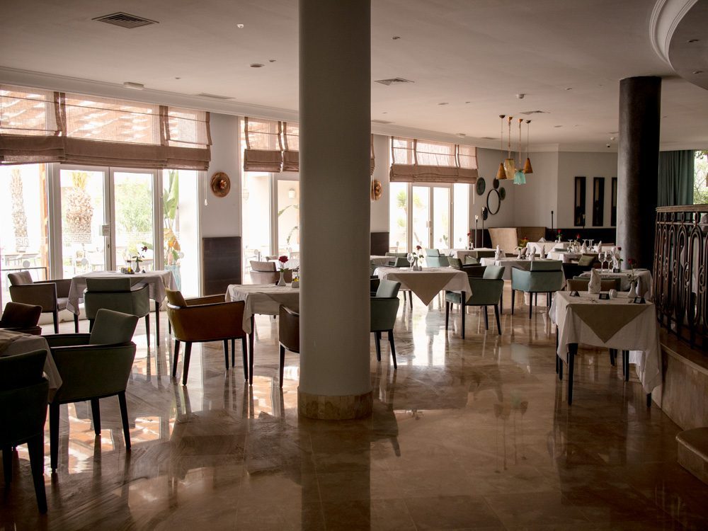 The Elegant VIP Suites at The Royal Thalassa Monastir 21 Inside the Mona Restaurant at the Royal Thalassa Monastir with central pillar and full length widows. White tablecloths with duck-egg blue, camel and beige chairs