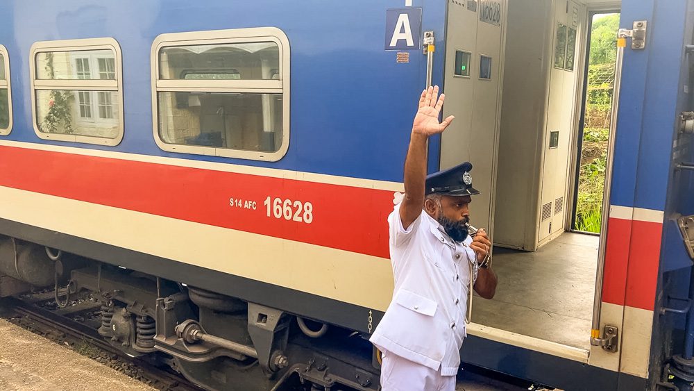 Why Amazing Sri Lanka Should Be Your Next Travel Destination (2025) 30 Trains in Sri Lanka with guard blowing his whistle wearing a white uniform