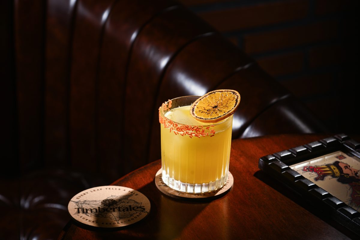 Stunning Timbertales In Coorg: A Tranquil Escape In Karnataka (2025) 19 Enjoy a cocktail in the Cellar Lounge - glass tumbler with a yellow cocktail with orange sprinkles round half the outside of the rim and a singed orange slice
