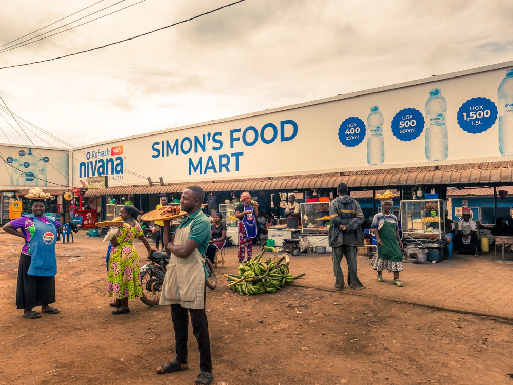 What to Eat in Uganda: A Delicious Journey Through Uganda’s Best Dishes 6 Street Market in Mubende - Simon's Food Mart with vendors holding platters of food in their hands or on their heads