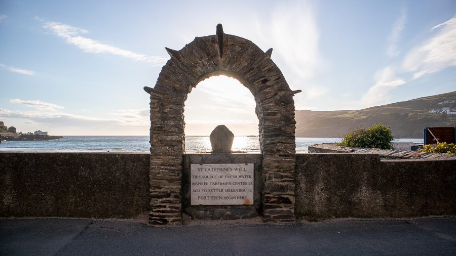 20+ Of The Best Things To Do In Port Erin, Isle Of Man 2 Arch above sign which says "St Catherine's Well, the source of fresh water inspired fishermen centuries ago to settle hereabouts. Port Erin Began Here," one of the things to do in Port Erin